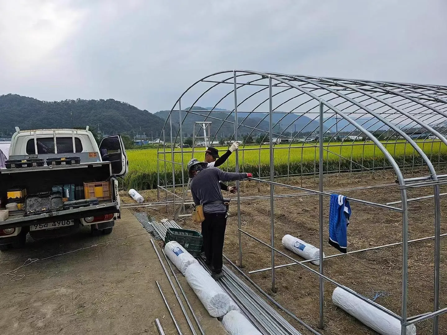 Workers assembling a single-span growing tunnel